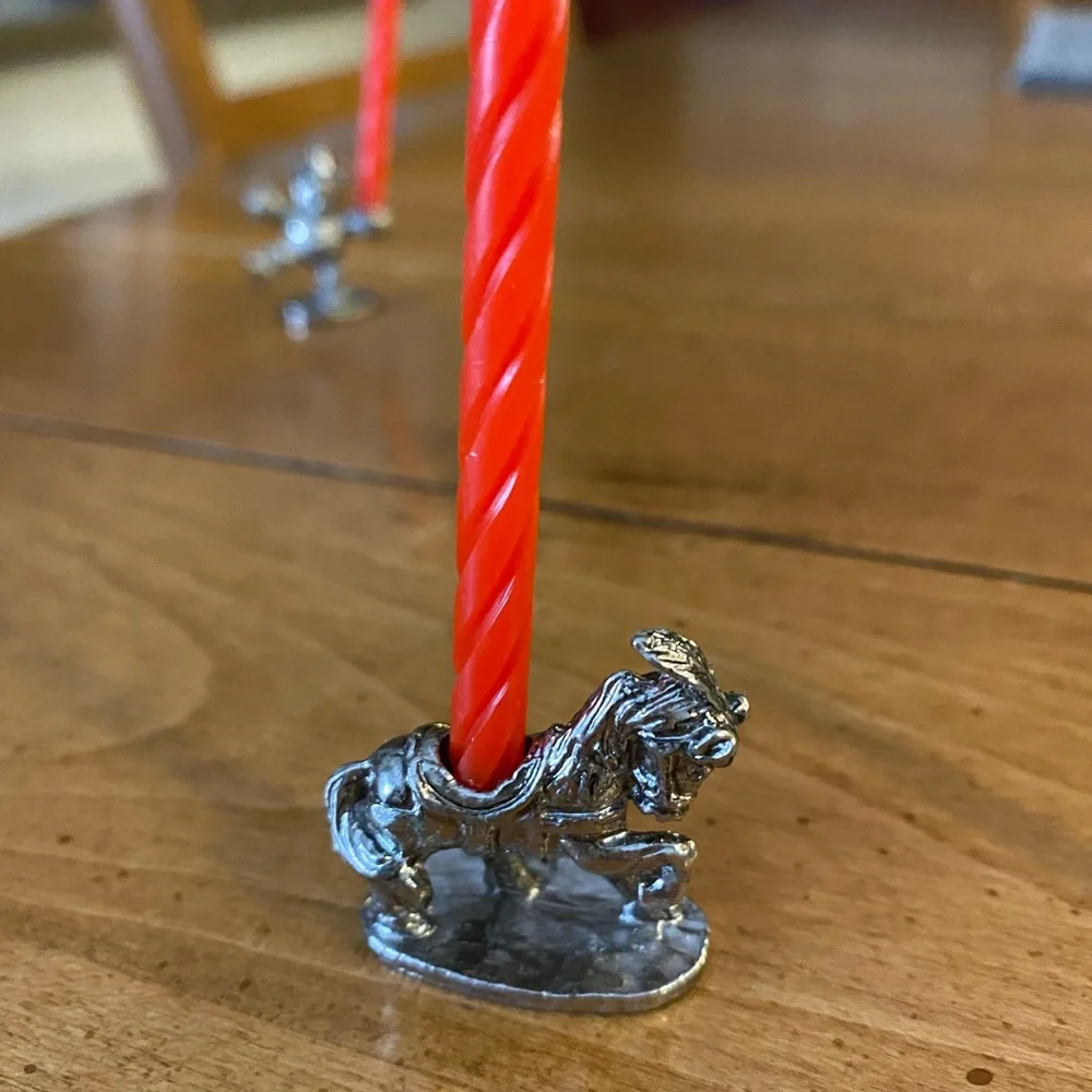 Set of animal candle holders stored in a metal tin.